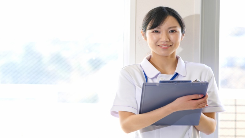 基本給や手当を確認している女性看護師のイメージ