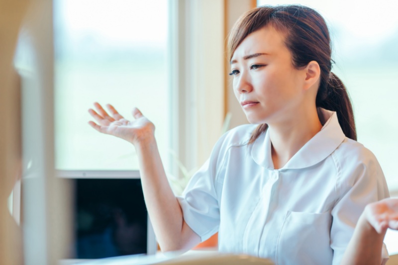 夜勤続きの負担について上司に相談し夜勤回数の調整を希望する女性看護師のイメージ