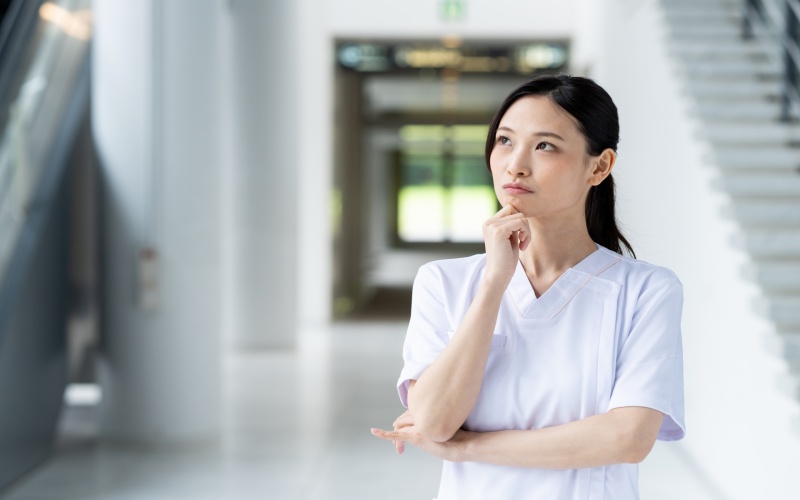 仕事を押し付けられて負担が増えている状況を上司へ相談する女性看護師のイメージ